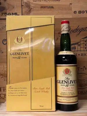 Vintage fles Glenlivet 12 Year Old Pure Single Malt Scotch Whisky uit de jaren '80, met klassiek crèmekleurig label en sierlijk logo, verpakt in een donkergroene of bruine fles met traditionele capsule en ingetogen, elegante uitstraling.