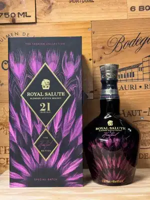 Limited edition Royal Salute 21 Year Old Harris Reed Edition in opvallende roze keramische fles met sierlijke gouden illustraties van veren en kroonmotieven, geïnspireerd op genderfluïde mode, gepresenteerd in een luxe geschenkdoos.