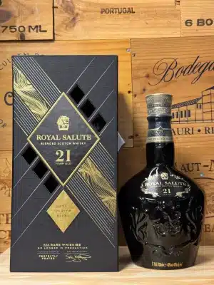 Keramische fles Chivas Regal The Peated Royal Salute 21 jaar, in diepe kleurstelling met gouden details en kroonembleem, speciaal geblend met rokerige maltcomponenten, gepresenteerd in een luxueuze fluwelen doos met koninklijke uitstraling.