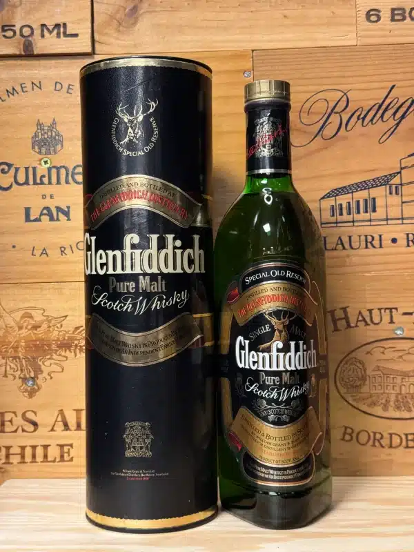 Vintage fles Glenfiddich Pure Malt Scotch Whisky uit de jaren '70 of '80, in iconische driehoekige fles met donkergroen glas, groen gouden label met hertensymbool en rode accenten, gepresenteerd in een kartonnen koker.
