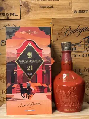Fles Royal Salute 21 Year Old Polo Estancia Edition, in een elegant lichtroze keramische fles met verfijnde gouden details en polo-geïnspireerde illustraties, gepresenteerd in een luxueuze geschenkdoos geïnspireerd op Argentijnse estancias en lifestyle.