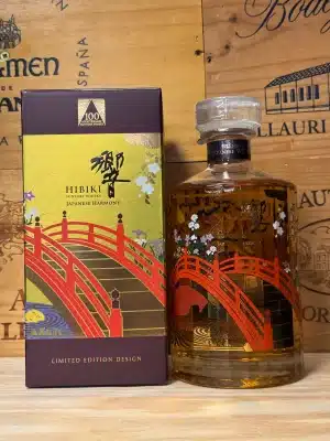 Fles Hibiki 100th Anniversary limited edition whisky met verfijnd veelhoekig design en speciaal jubileumetiket, naast luxe geschenkdoos
