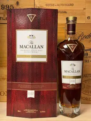 Fles Macallan Rare Cask 2022 in luxueuze rode doos met gouden details, premium single malt whisky elegant gepresenteerd tegen een donkere achtergrond.