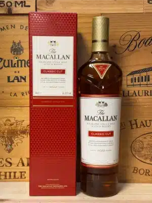 Fles Macallan Classic Cut 2022 in stijlvolle rode verpakking met witte en gouden accenten, premium single malt whisky gepresenteerd tegen een elegante achtergrond.