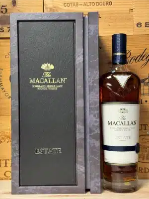 Fles Macallan Estate in elegante zwarte doos met leisteenaccent en luchtfoto van het Macallan-landgoed, premium single malt whisky uit Speyside.