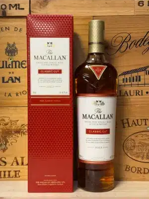Fles Macallan Classic Cut 2023 in stijlvolle rode verpakking met gouden accenten, single malt whisky gepresenteerd op een elegante achtergrond.